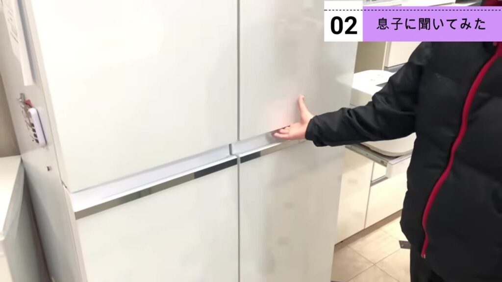 冷凍庫が大きい冷蔵庫の扉を開ける息子