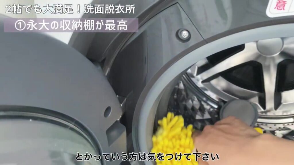 ドラム式洗濯機のパッキンをモップで掃除するところ