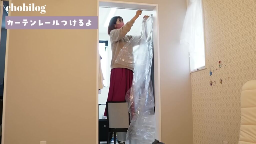 納戸の入り口にビニールカーテンを取り付ける様子
