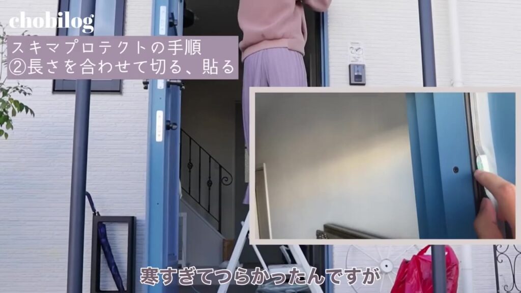 玄関ドアの枠に隙間テープを貼る様子