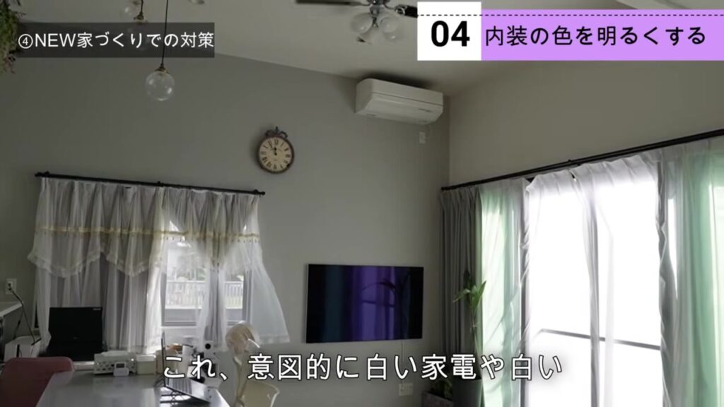 一面だけ薄いグレーで他は白でまとめた明るい内装のリビング