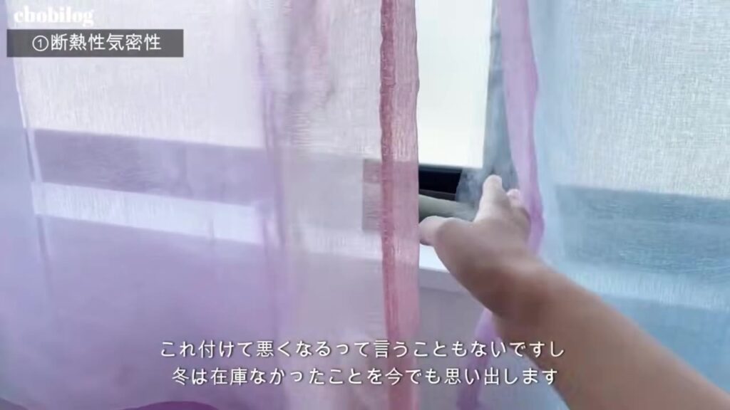 子供部屋の窓のビニールカーテンのすき間に手を入れる様子