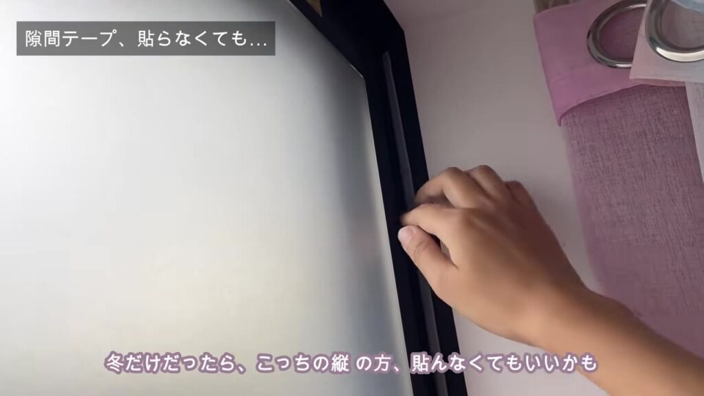 窓の縦のサッシに隙間テープを挟んでいるところ