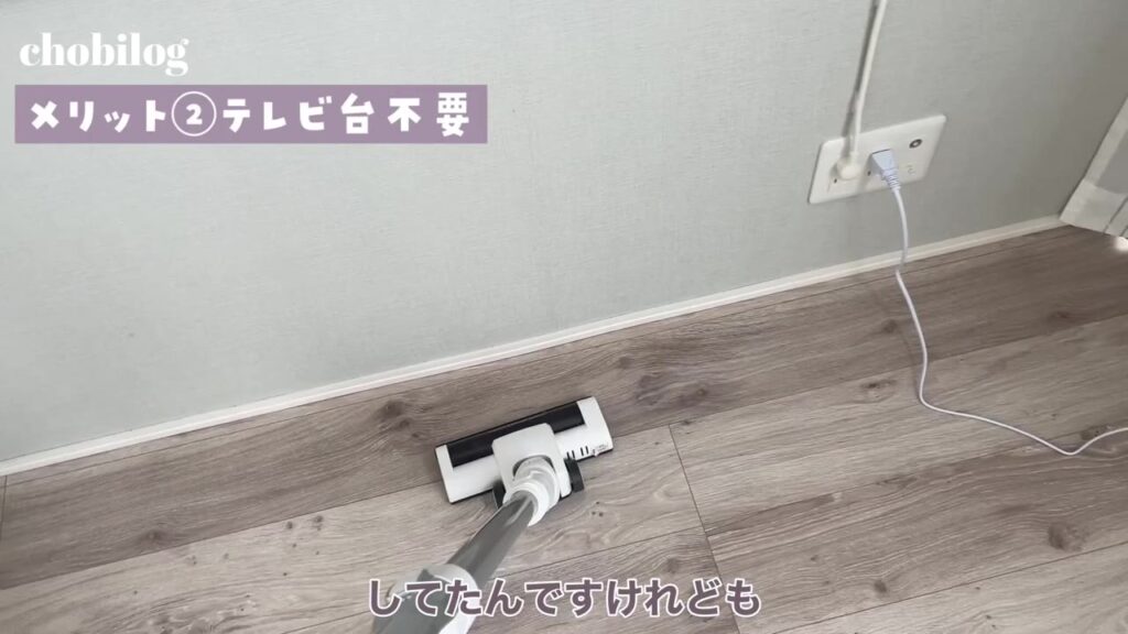 テレビ台がなくなった壁際を掃除機で掃除する様子