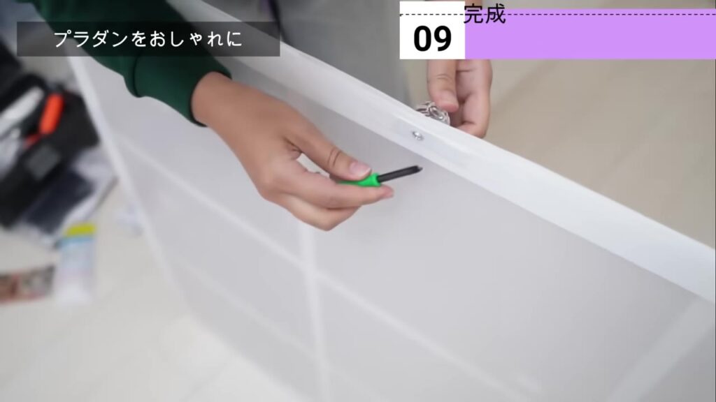 プラダン二重窓に100均の透明な取っ手をネジで付けているところ