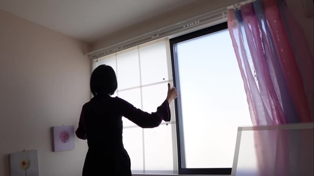 窓枠にはめたプラダン二重窓を開け閉めしているところ